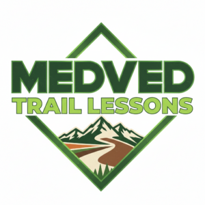 Medved Trail Lessons logo featuring a mountain landscape and winding trail inside a green diamond frame.
