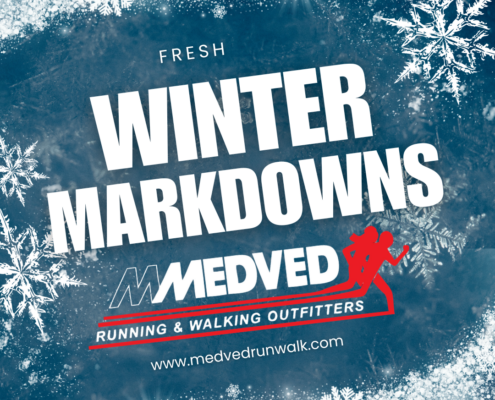 Square promotional graphic with an icy blue background, frosty border, and white snowflakes. Large white text in the center reads ‘FRESH WINTER MARKDOWNS.’ Below is the Medved Running & Walking Outfitters logo with a red silhouette of two runners and the website ‘www.medvedrunwalk.com’ at the bottom